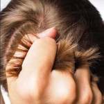 mano agarrando un puñado de cabello. La tricotilomania es un trastorno que hace que nos arranquemos el cabello.